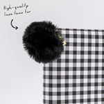 Black faux fur keyring attached to buffalo check planner